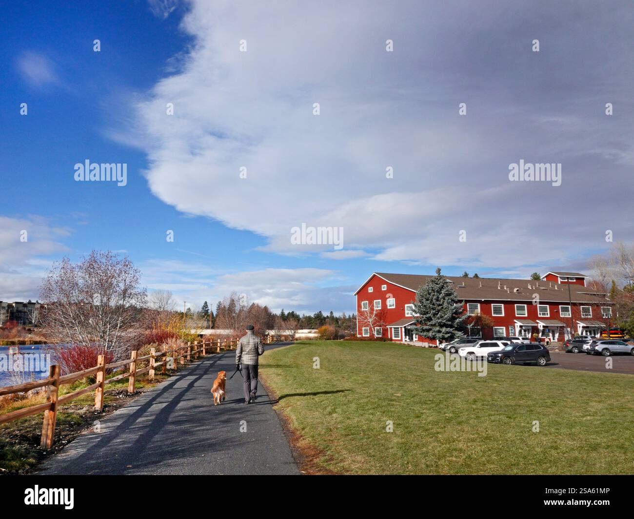 Passerella pavimentata lungo il fiume Deschutes nell'area commerciale Old Mill di Bend, Oregon. Foto Stock