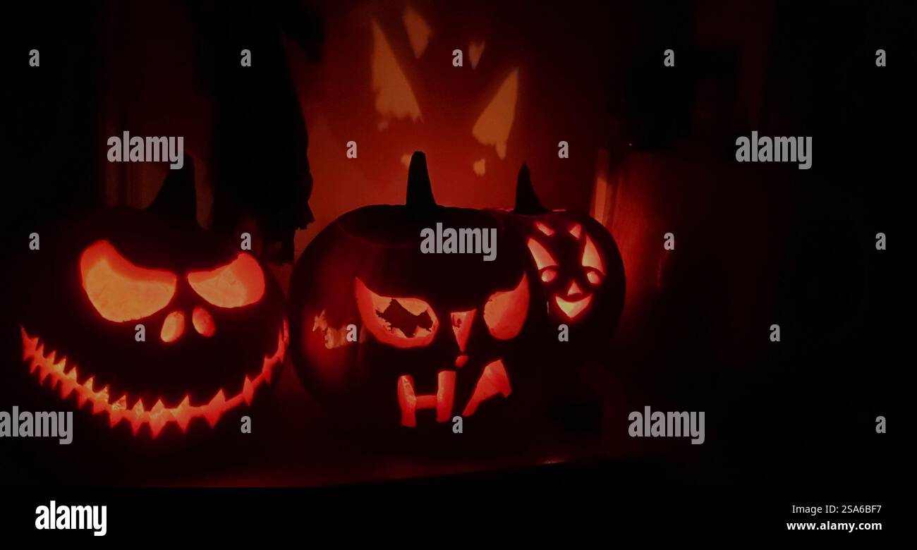 Zucche di Halloween con volti spaventosi su sfondo scuro Foto Stock