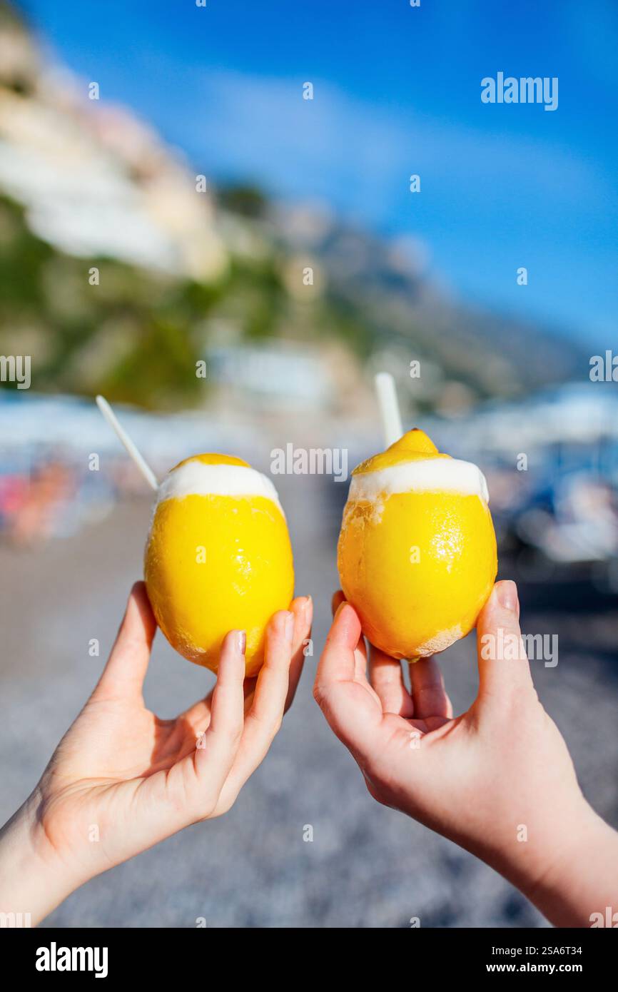 Primo piano di due mani con limoni freschi ripieni di sorbetto Foto Stock