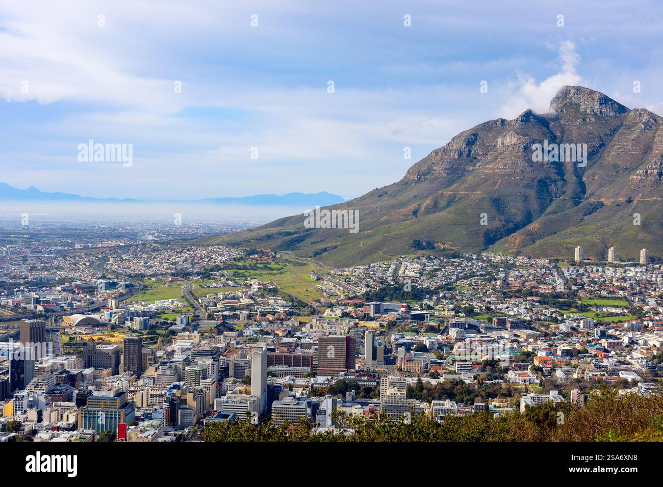Una splendida vista del vivace paesaggio urbano di città del Capo con la sua architettura variegata, circondata da paesaggi verdi e dominata dalla maestosa Table Mo Foto Stock