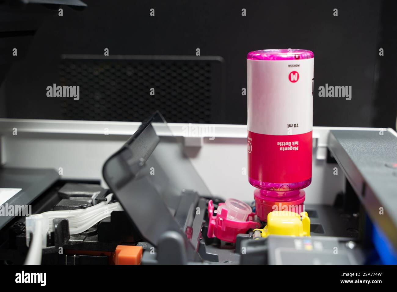Flaconi di inchiostro con stampante con serbatoio d'inchiostro. Primo piano riempimento dell'inchiostro in una stampante con serbatoio d'inchiostro rosso in ufficio. Cartucce e contenitori del sistema di erogazione continua dell'inchiostro Foto Stock