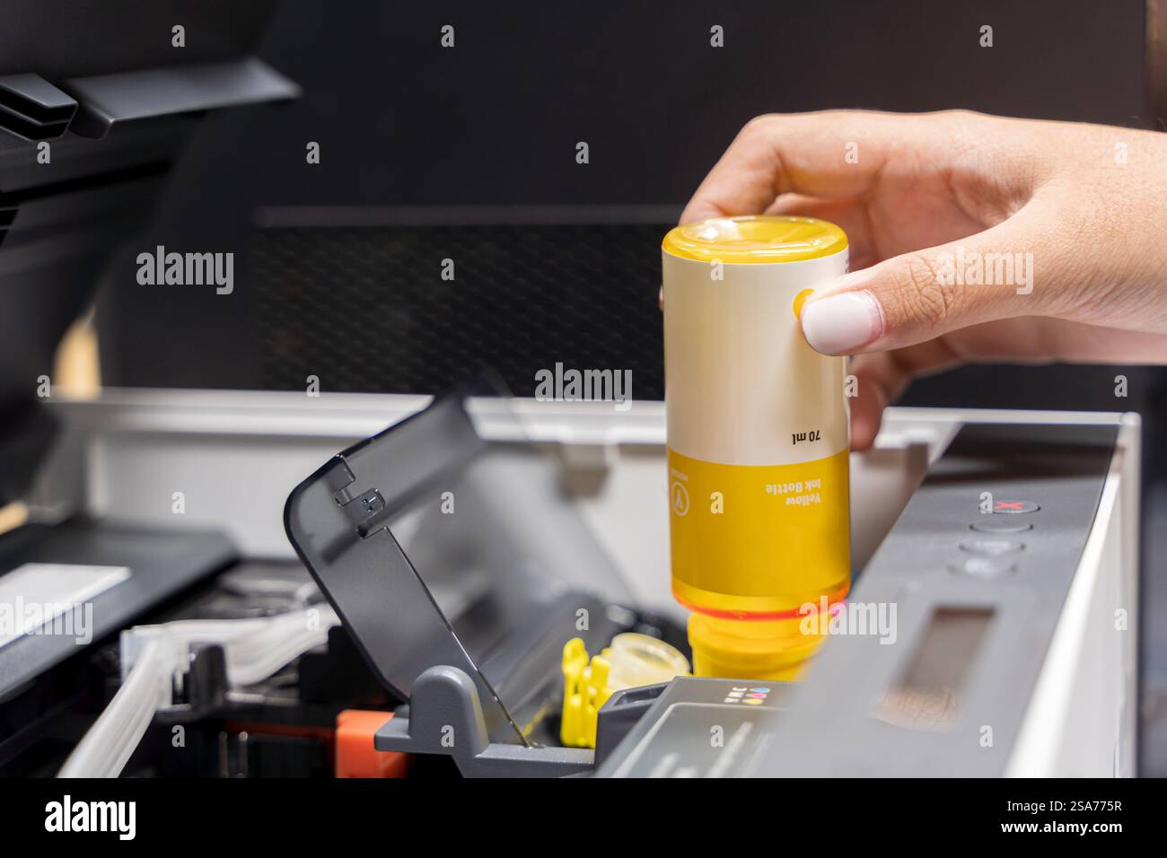 Ricaricare la stampante con serbatoio d'inchiostro in ufficio. Primo piano cartuccia di stampa getto d'inchiostro di colore giallo CMYK e riparare il concetto di problema , messa a fuoco selettiva Foto Stock