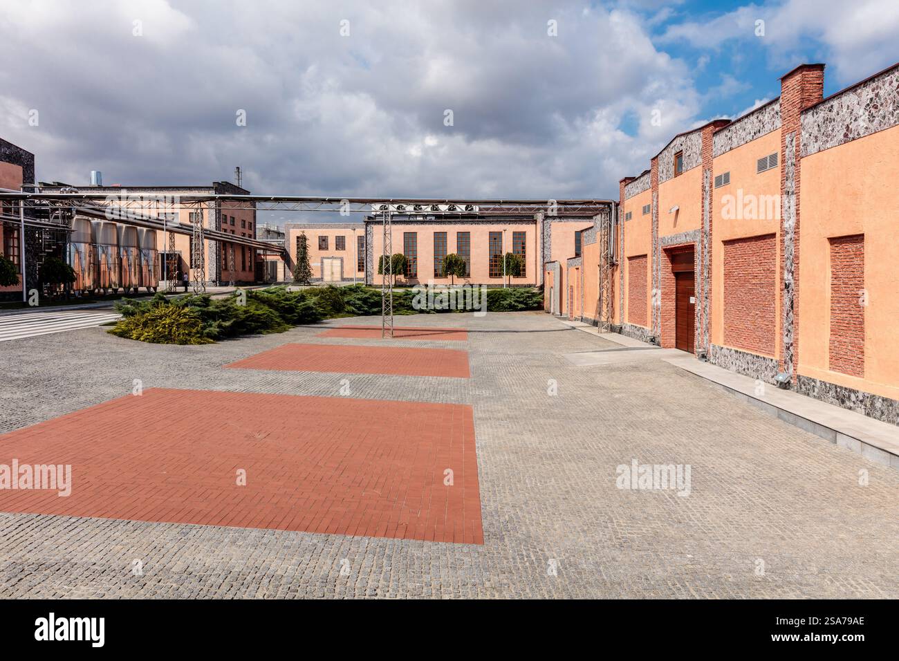 Il cortile è un grande spazio vuoto con pochi alberi sparsi ovunque. Gli edifici che circondano il cortile sono vecchi e hanno un aspetto rustico Foto Stock