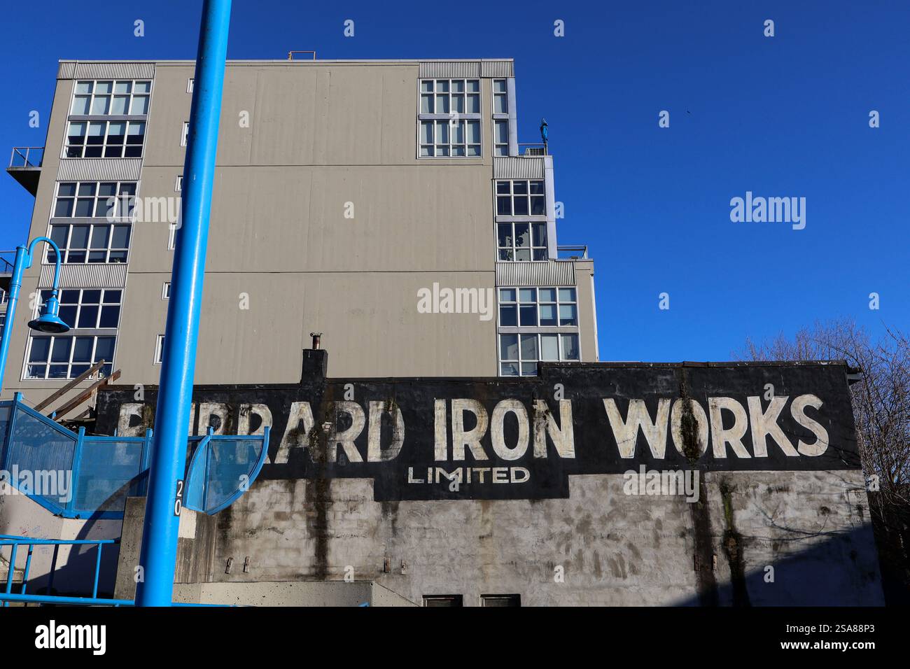 Il cartello fantasma vintage per Burrard Iron Works in prossimità di Main Street a Vancouver, British Columbia. L'azienda produce macchinari per navi dal 1912. Foto Stock