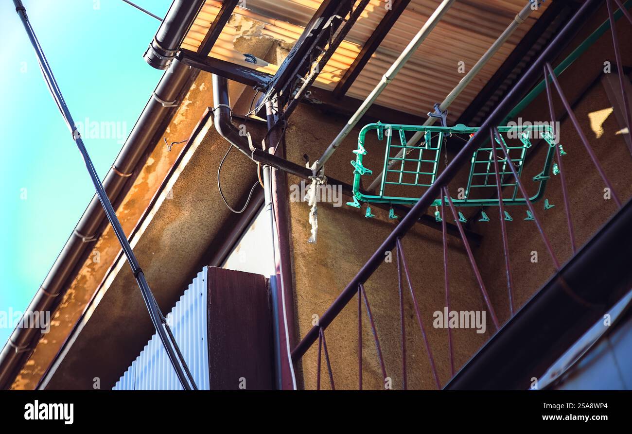 Un appendiabiti vuoto di plastica per asciugare i vestiti appesi sul balcone del secondo piano di un vecchio condominio nella parte ovest di Tokyo Foto Stock
