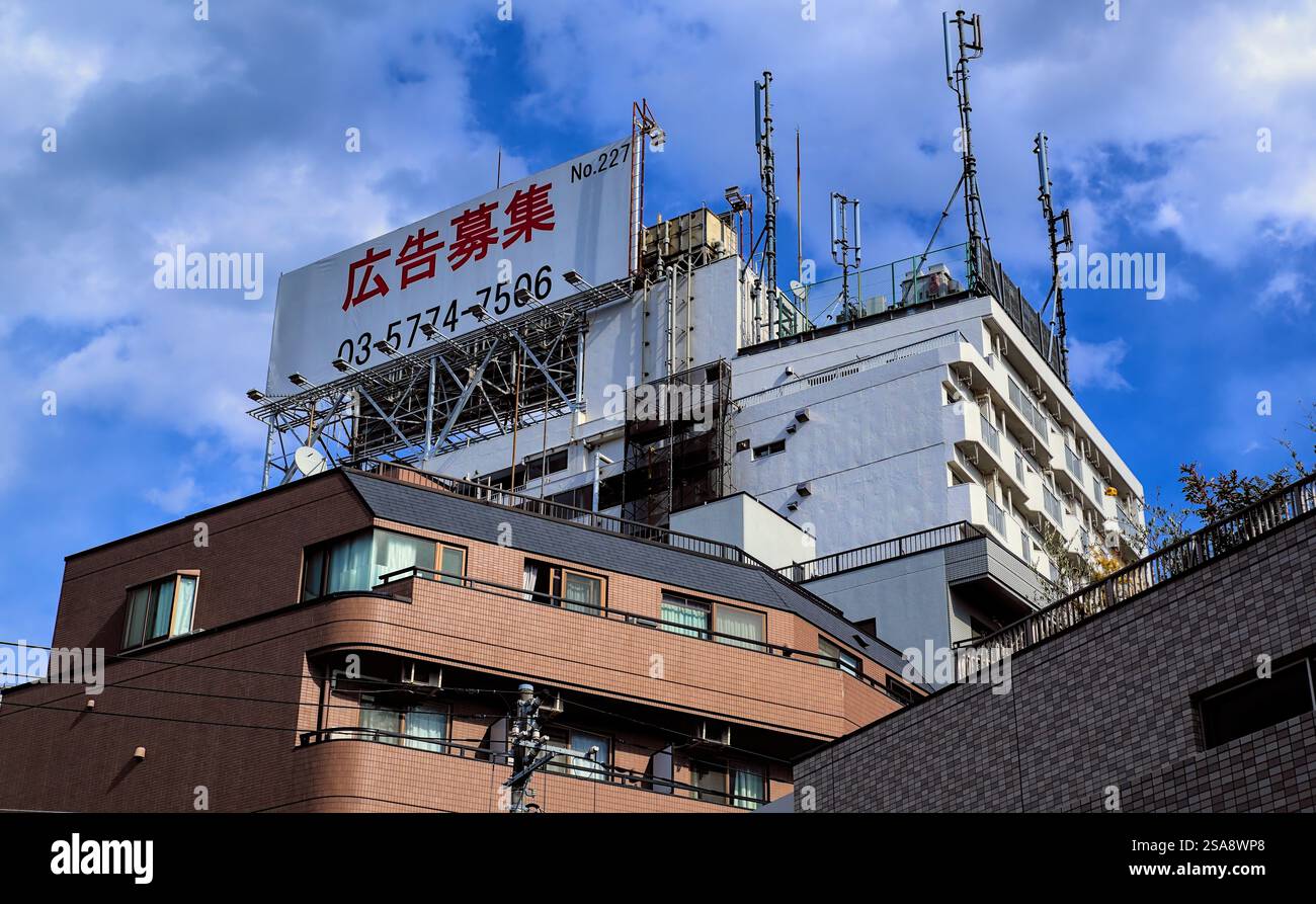 Un cartellone inutilizzato in cima ad un alto edificio di appartamenti nella parte ovest di Tokyo, che dichiara in giapponese che il cartellone è disponibile per la pubblicità Foto Stock