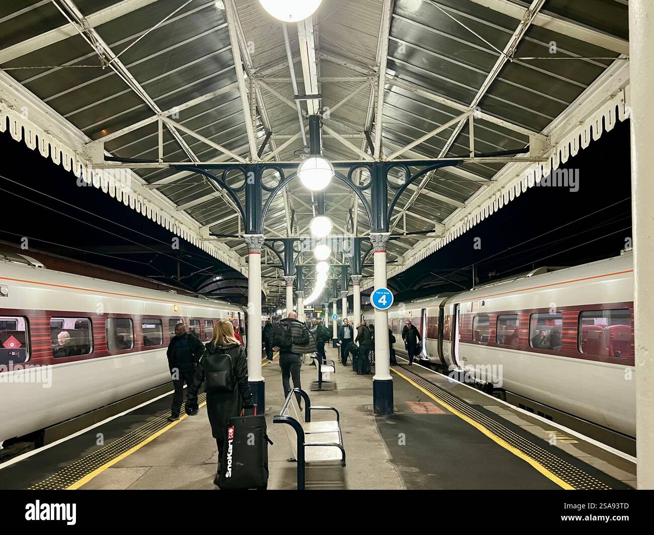 Passeggeri in attesa nella magnificenza della stazione ferroviaria di York, North Yorkshire, North East England, Regno Unito Foto Stock