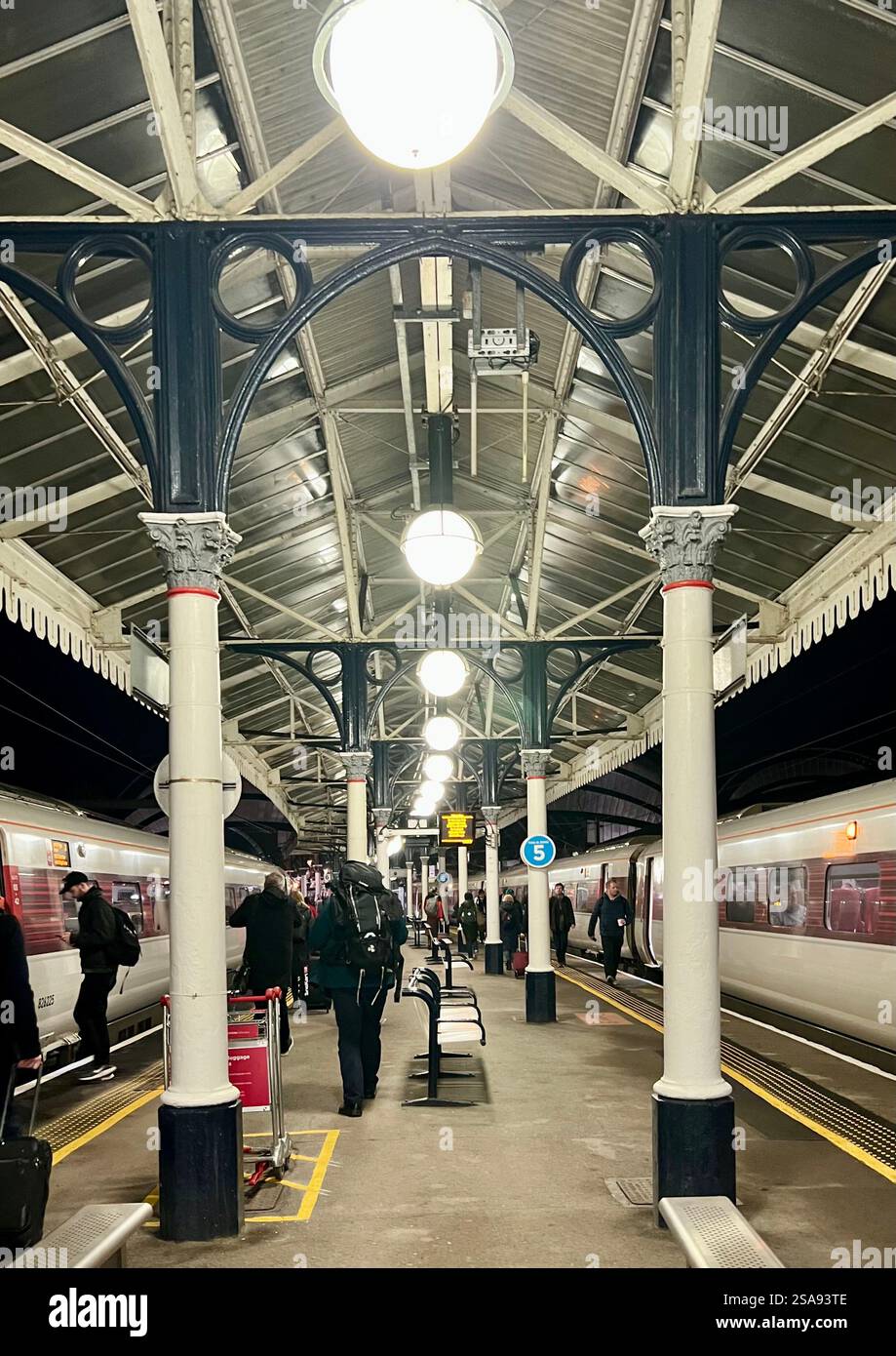 Passeggeri in attesa nella magnificenza della stazione ferroviaria di York, North Yorkshire, North East England, Regno Unito Foto Stock