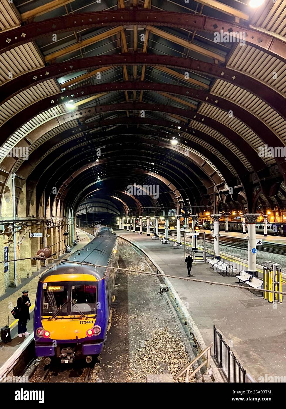 Passeggeri in attesa nella magnificenza della stazione ferroviaria di York, North Yorkshire, North East England, Regno Unito Foto Stock