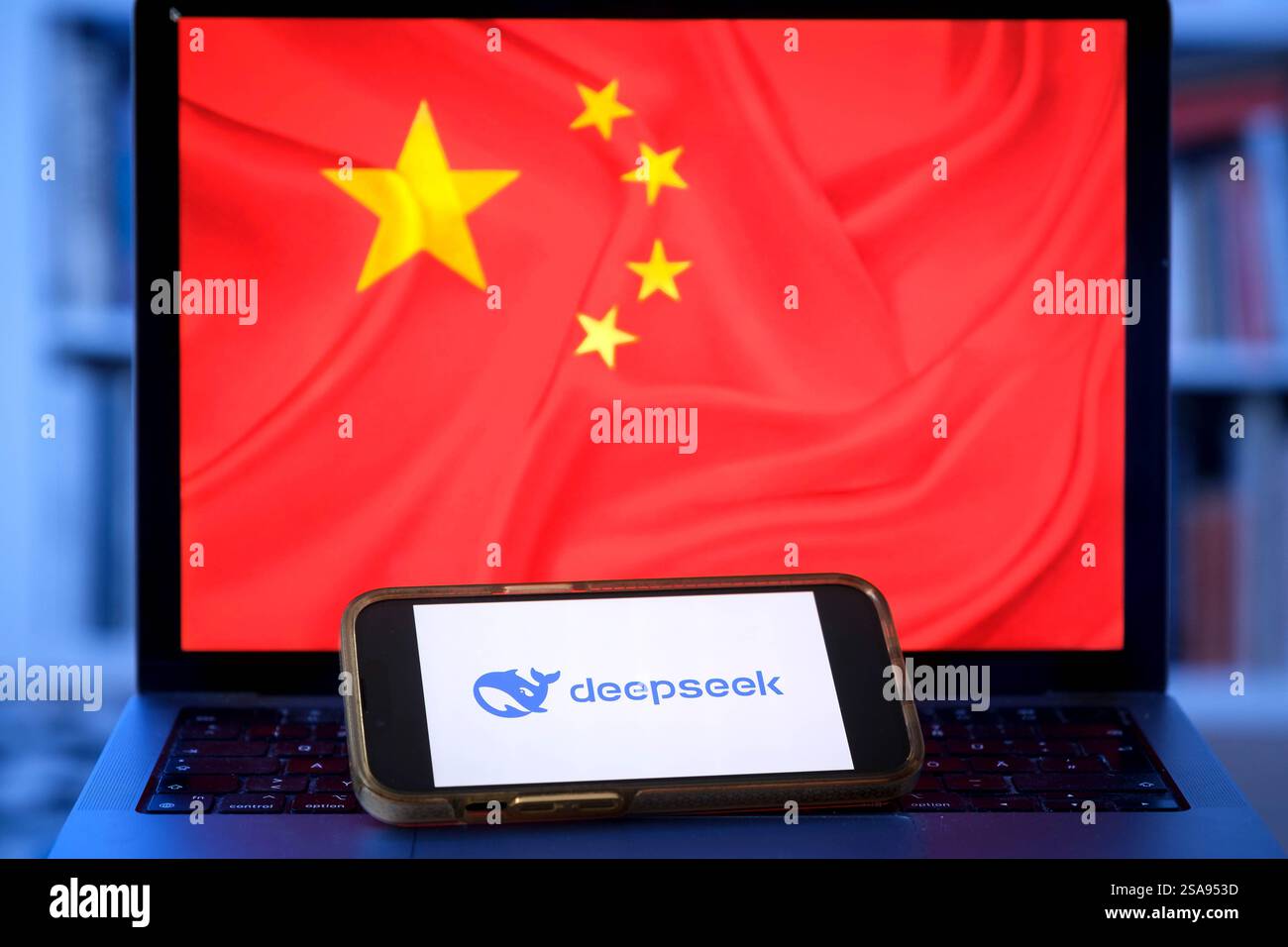 Telefono cellulare con il logo del chatbot cinese Deepseek davanti a un laptop con la bandiera cinese (foto simbolica) Foto Stock