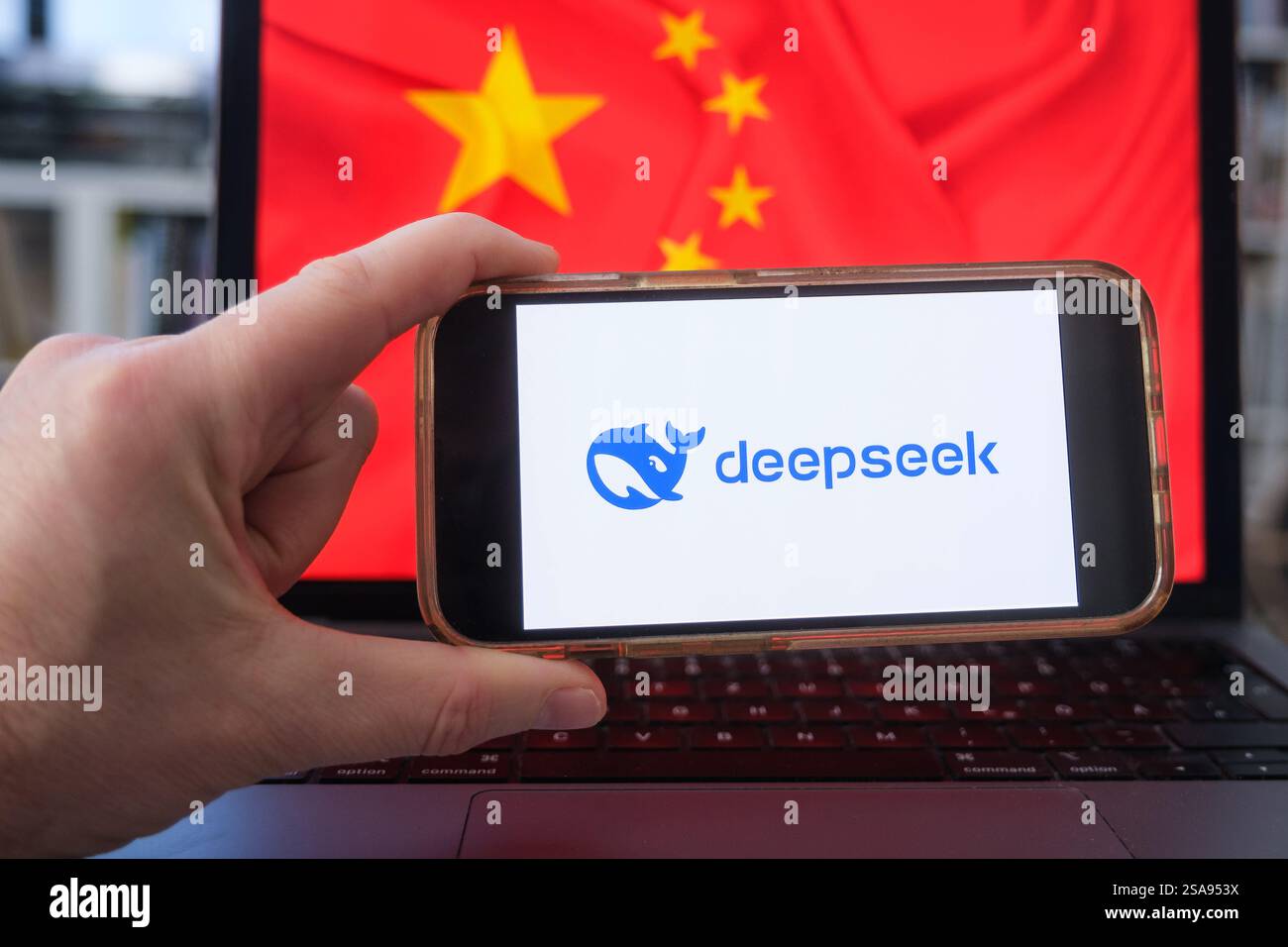 Telefono cellulare con il logo del chatbot cinese Deepseek davanti a un laptop con la bandiera cinese (foto simbolica) Foto Stock
