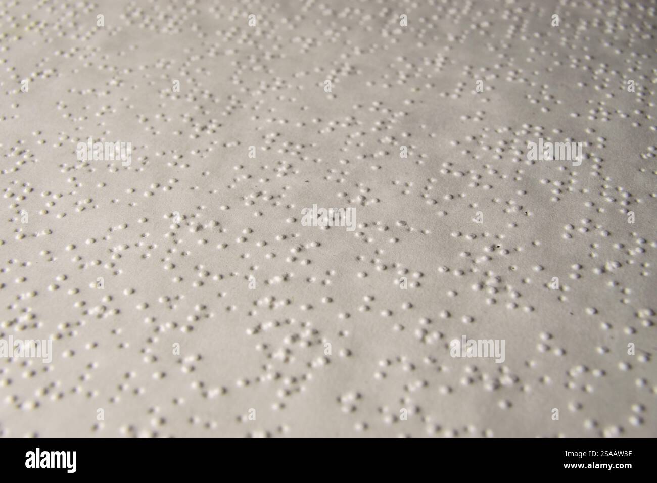 White paper stampato in Braille Alphabet. Carta stampata in alfabeto Braille. Scatto macro. Luminosità e bassa profondità di campo. Libro per i non vedenti. Foto Stock