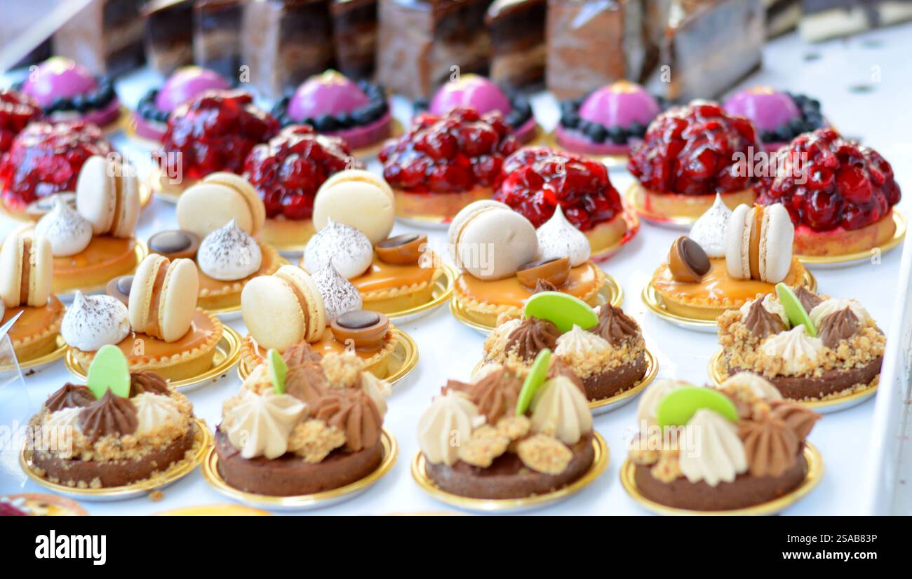 Cupcake colorati ricoperti di frutta fresca, esposti in un negozio di dolci, con dessert vivaci e deliziosi, perfetti per ogni occasione o festa Foto Stock