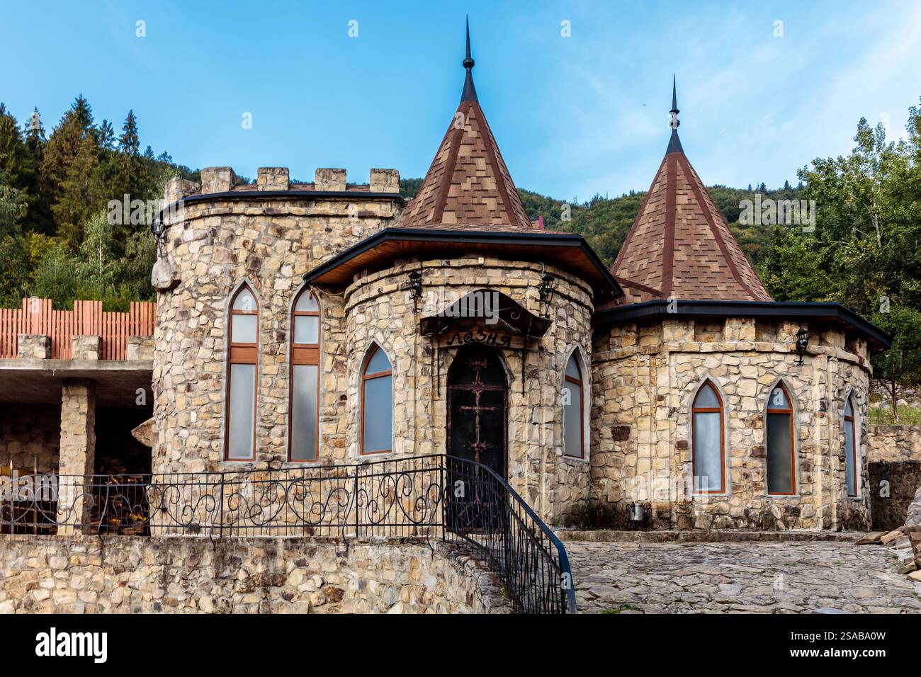 Un grande edificio in pietra con un tetto appuntito e una piccola finestra. L'edificio ha un aspetto simile a un castello Foto Stock