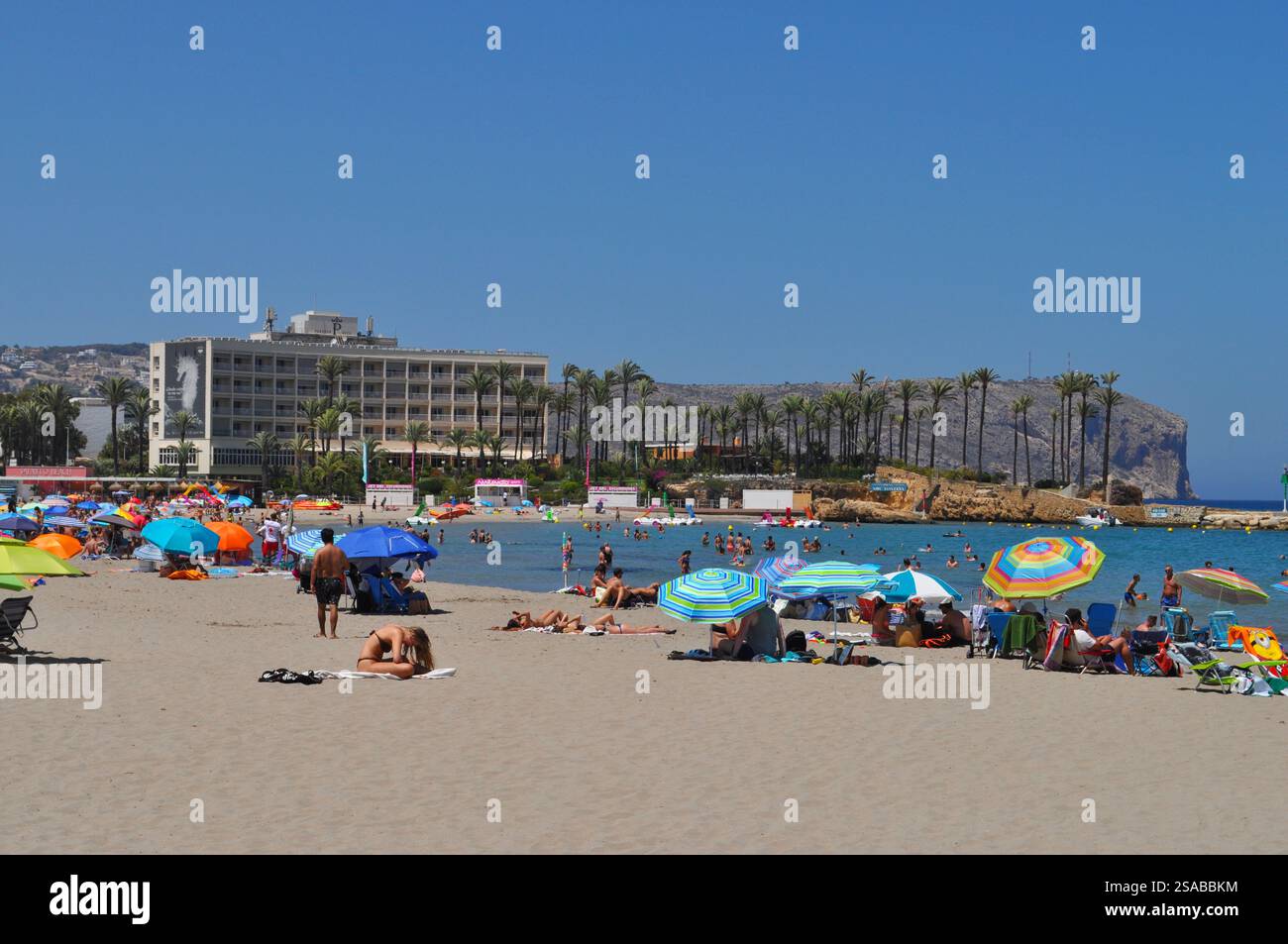 Spiaggia di Arenal affollata e colorata con gente che nuota e prende il sole, Parador sullo sfondo Foto Stock
