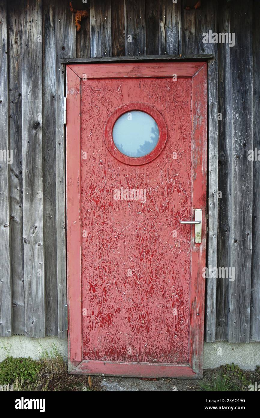 Porta rossa di legno sul capannone di pesca Foto Stock