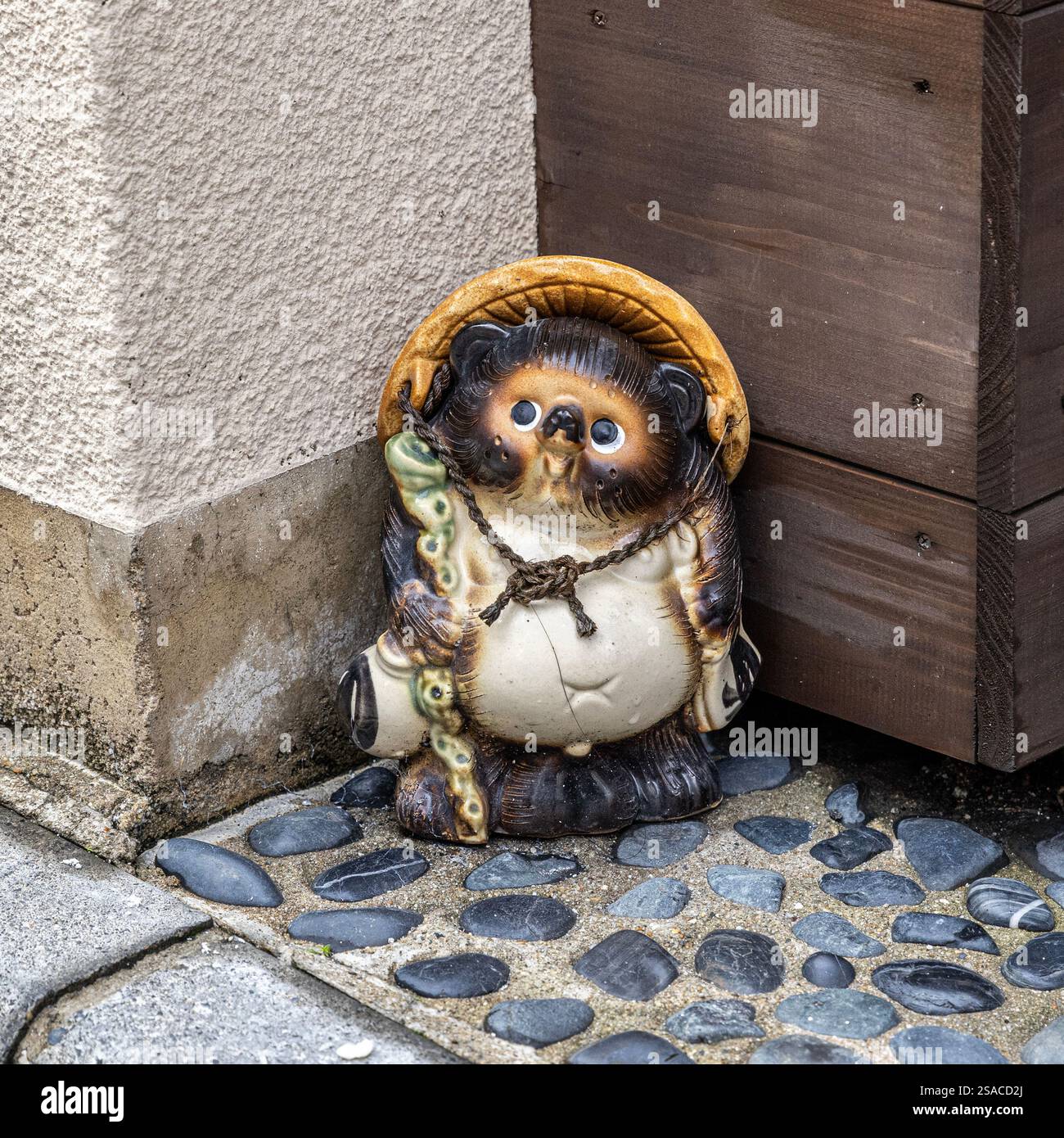Statua di Tanuki che indossa un cappello e tiene in mano il personale a Kyoto in giappone Foto Stock