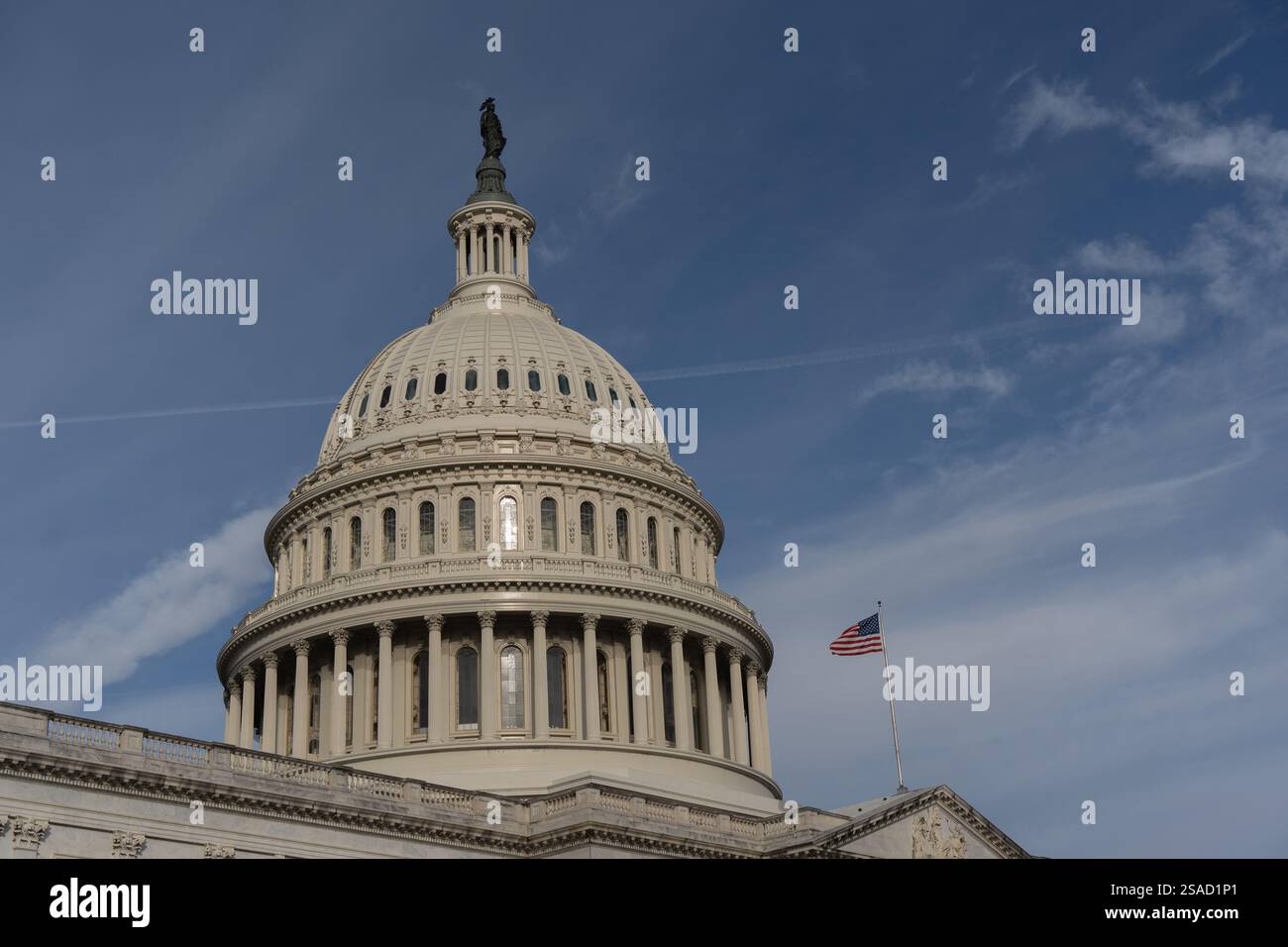 Washington DC - 27 ottobre 2024: United State Capitol Building Dome con bandiera americana su sfondo blu Foto Stock