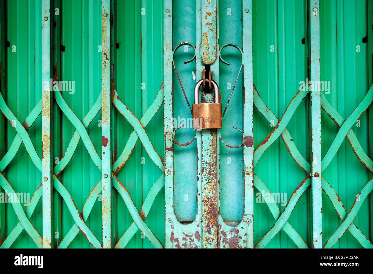 Lucchetto sulla porta metallica di un punto vendita. Tan Chau. Vietnam. Foto Stock