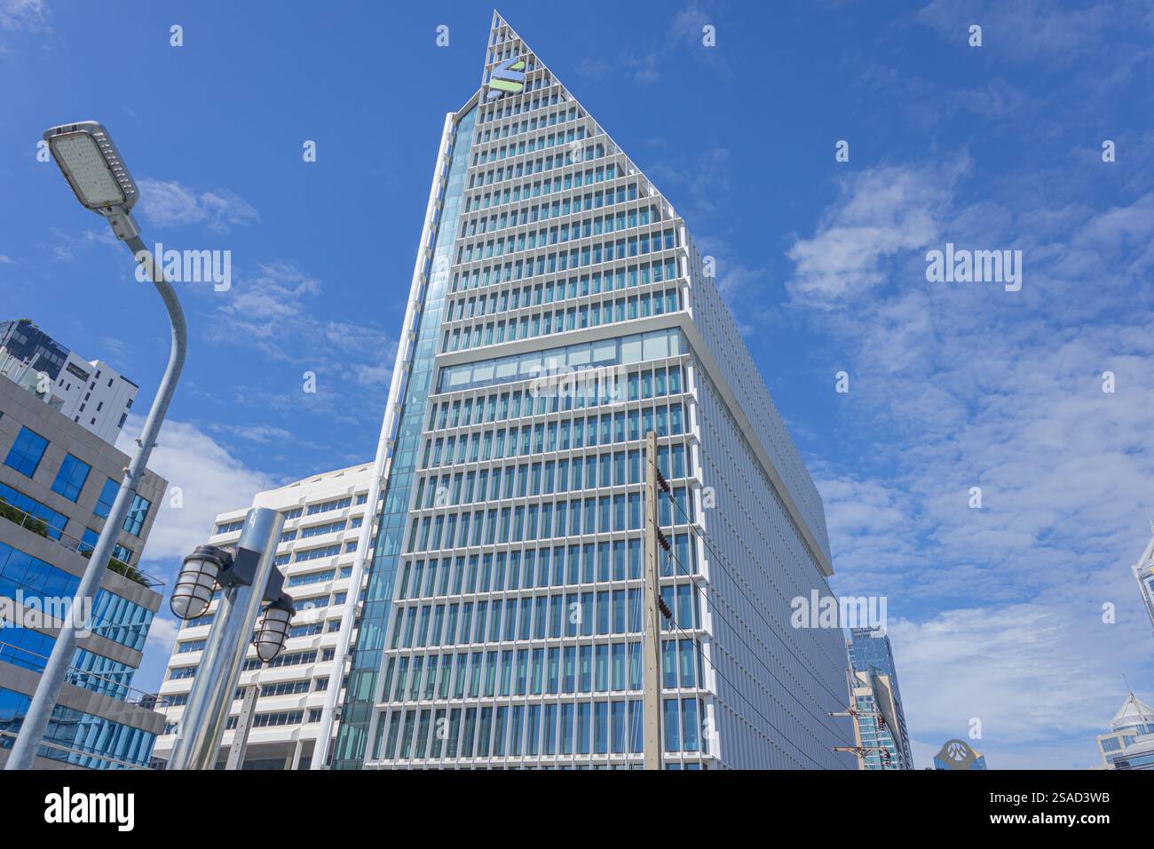Uno splendido e moderno edificio dall'elegante design triangolare, che torreggia contro il cielo blu. Una meraviglia architettonica che mostra la città di innova Foto Stock Uno splendido e moderno edificio dall'elegante design triangolare, che torreggia contro il cielo blu. Una meraviglia architettonica che mostra la città di innova Foto Stock