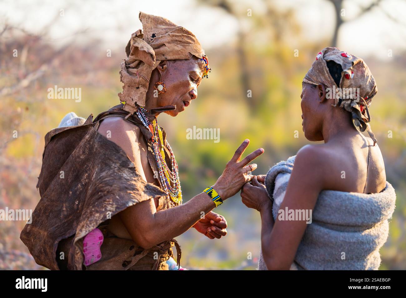 Makgadikgadi Pans, Botswana - 14 luglio 2024: Due donne tribali del Botswana si impegnano in una discussione significativa, adornate con abiti tradizionali con colorfu Foto Stock