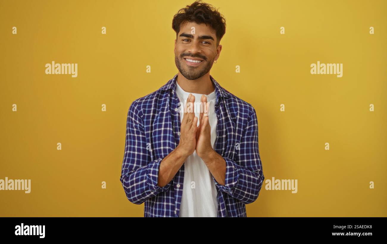 Giovane ispanico che batte le mani su uno sfondo giallo isolato, mostrando felicità e sicurezza, vestito con stile con la barba in un abbigliamento casual Foto Stock