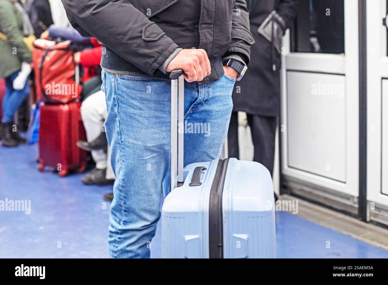 uomo che tiene la maniglia della valigia in metropolitana Foto Stock