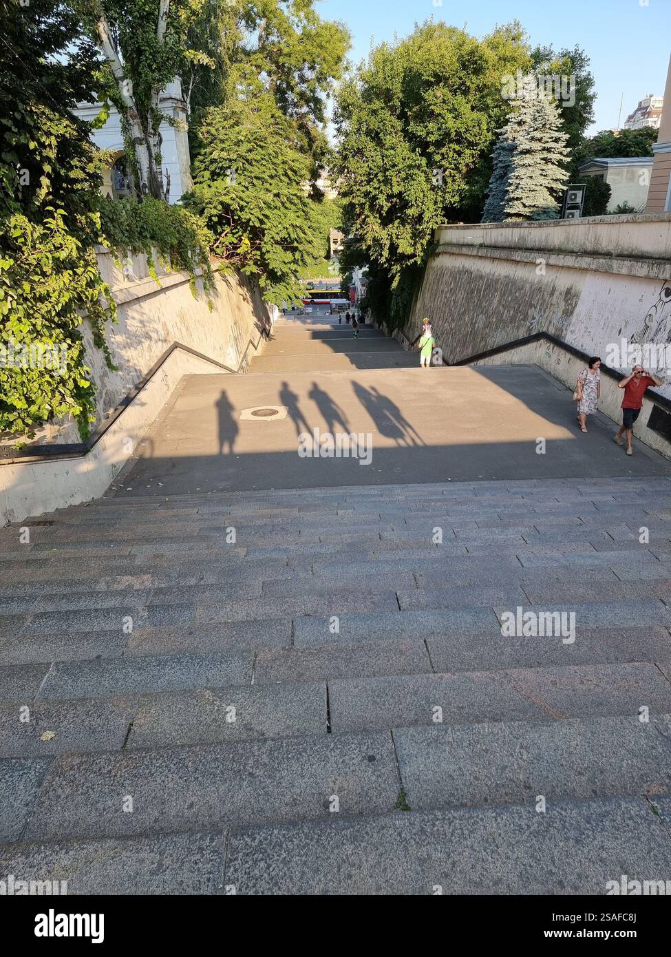Ombre di un gruppo di 5 persone, viste dalle scale di una città; concettuale, ad esempio in piedi in alto, guardando in basso; sagome Foto Stock