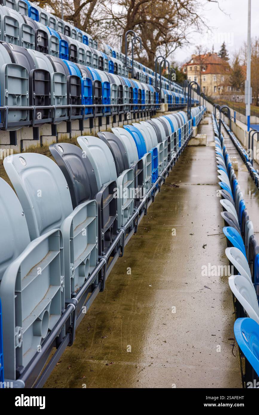 Corridoio tra i posti numerati blu e grigio in uno stadio. Sedili ripiegati in uno stadio. Foto Stock