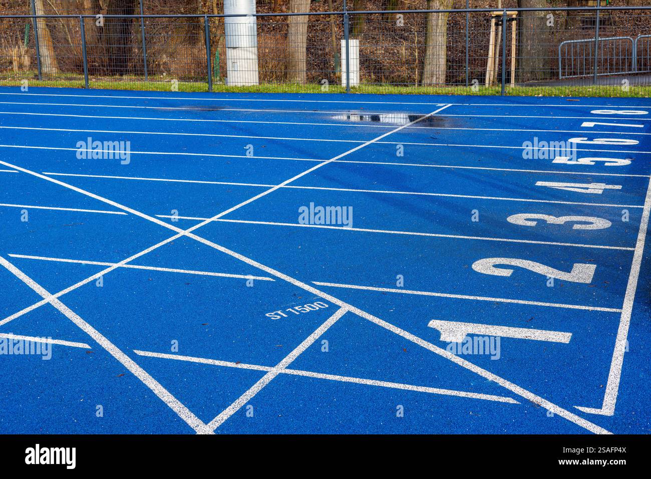 Pista da corsa blu allo stadio con numeri da uno a otto. Area di partenza allo stadio. Foto Stock