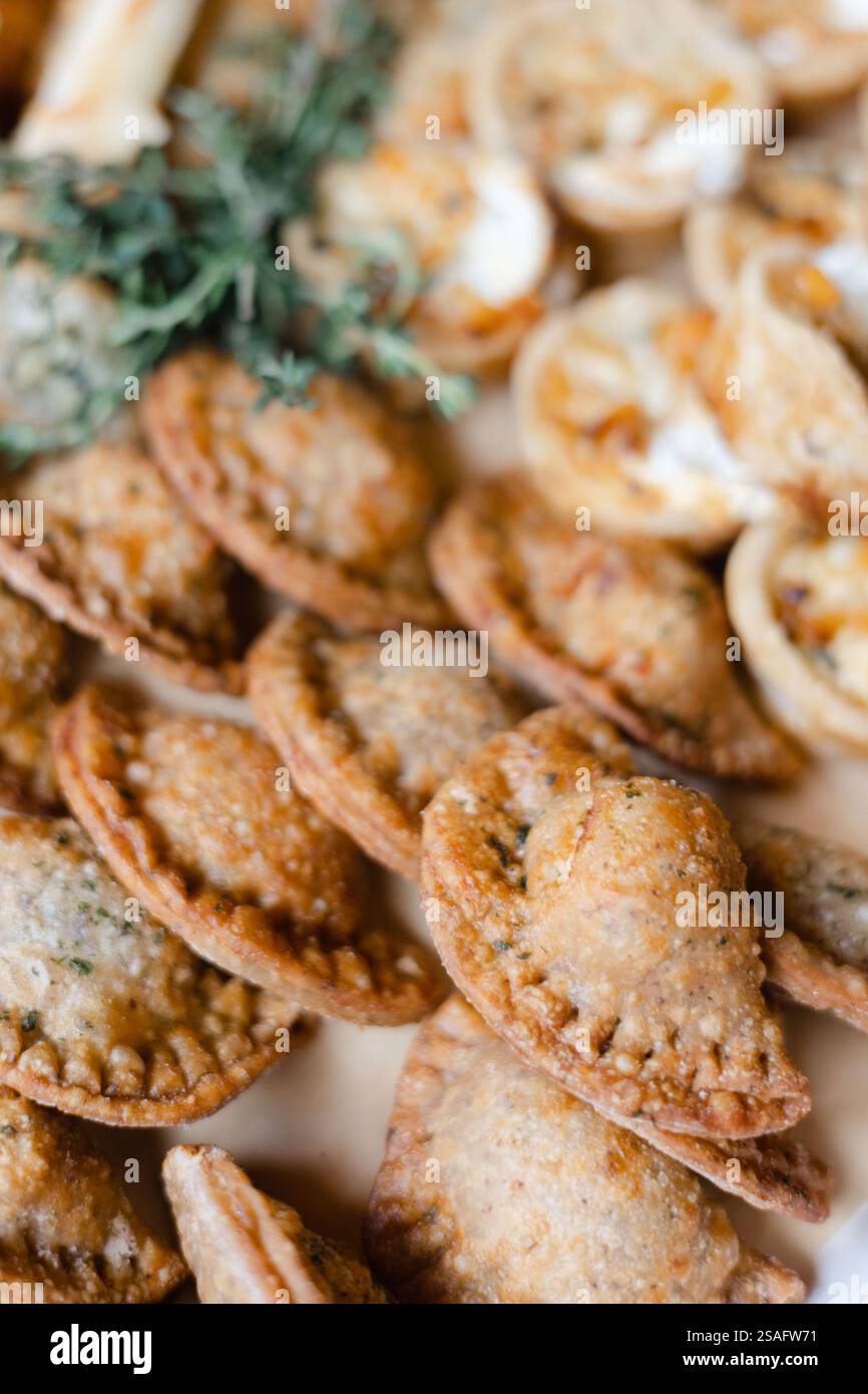 Un'invitante varietà di dolci appena sfornati, tra cui mini torte e salati, guarniti con erbe aromatiche, perfetti per socializzare Foto Stock