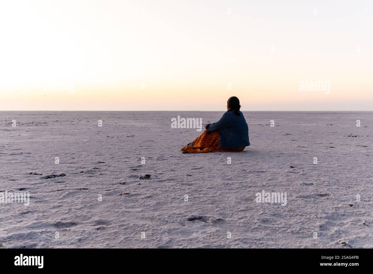 ragazza che si diverte in un remoto deserto di sale bianco con un cielo luminoso al mattino da un'angolazione bassa Foto Stock