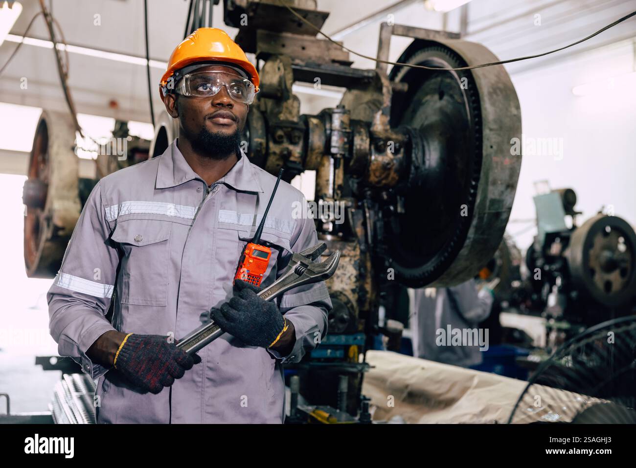 ritrattista professionista che lavora in una fabbrica di metalli pesanti guarda lontano orgoglioso successo Foto Stock