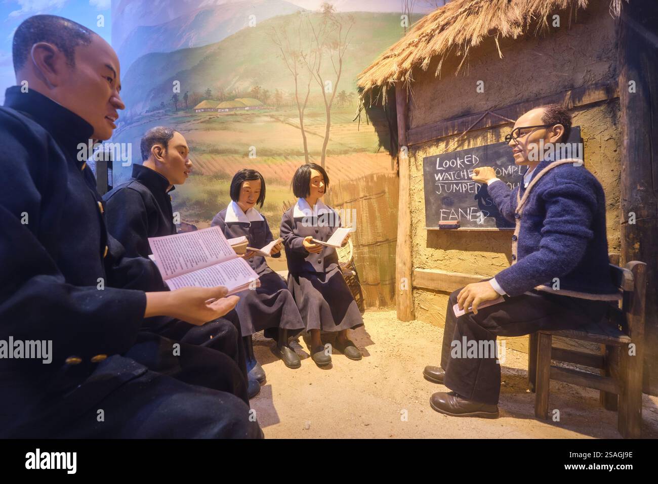 Alle ragazze delle scuole e agli adulti che vengono insegnati. Fa parte di un diorama della vita post-bellica. Al War Memorial of Korea Museum di Seoul, Corea del Sud. Foto Stock