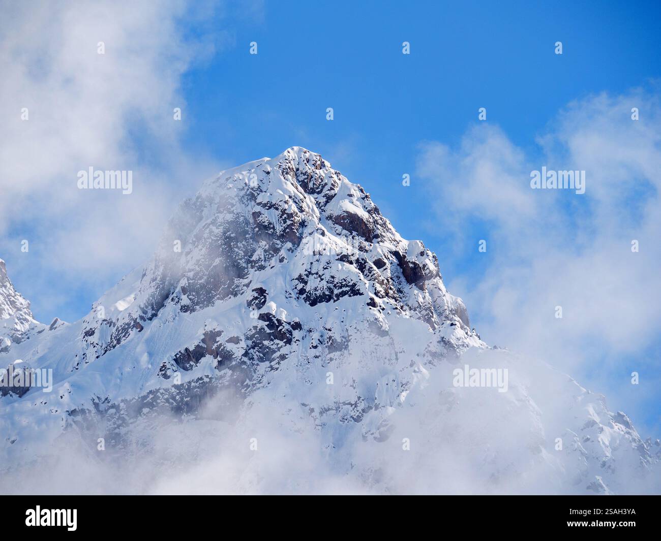 Nursultan Peak, vecchio nome Pioneer Peak. Un picco sui monti Tien Shan vicino alla città di Almaty. La cima innevata è avvolta da nuvole di luce a poppa Foto Stock