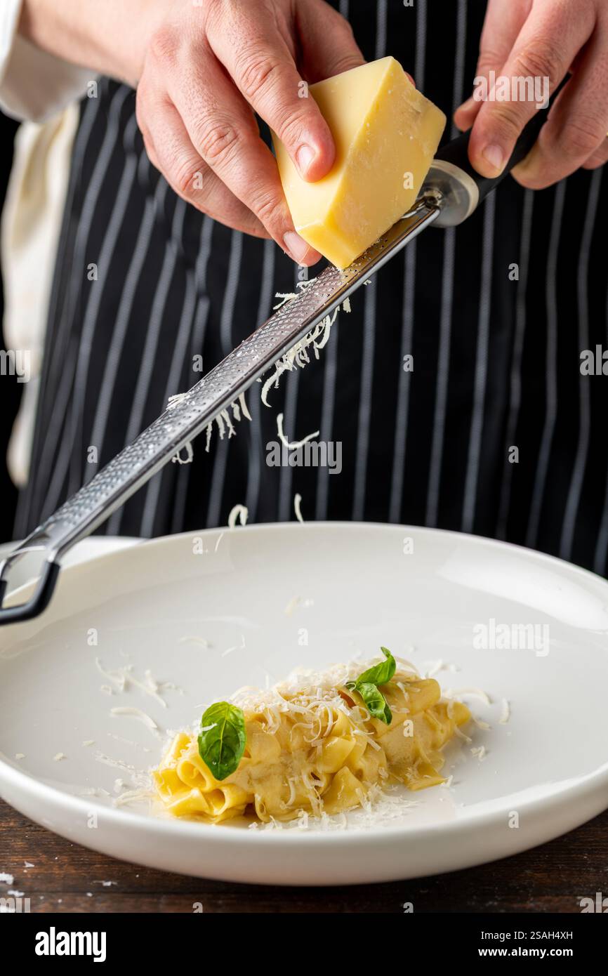 Deliziosa pappardelle di pasta italiana con parmigiano in porcellana bianca su un tavolo di legno Foto Stock