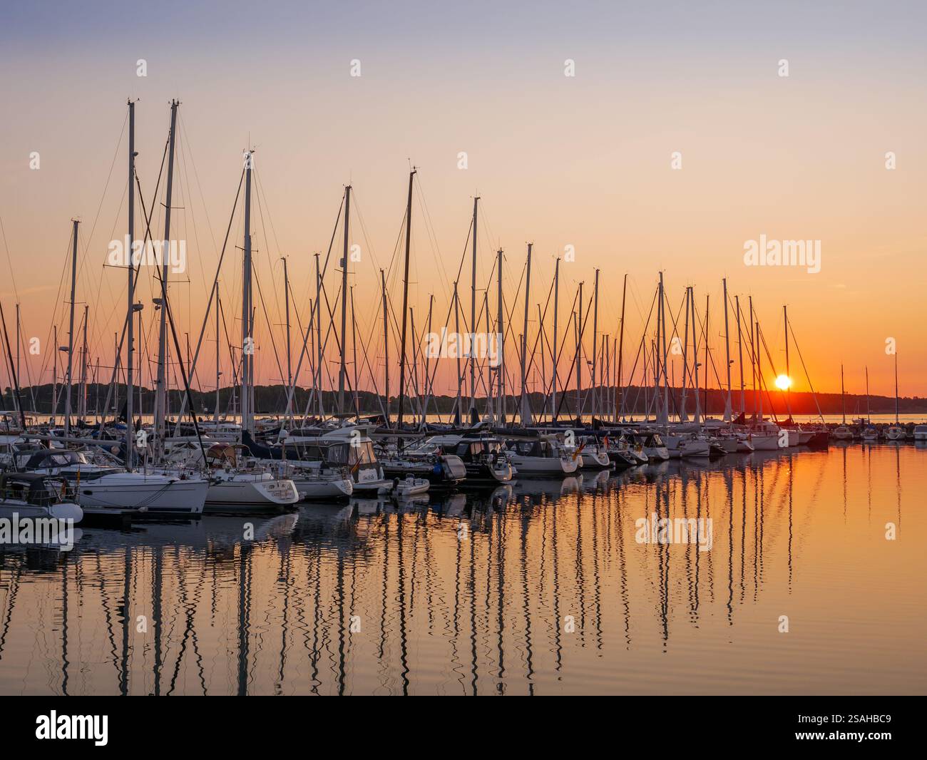 Fila di barche a vela ormeggiate nei posti di ormeggio di Baltic Bay Marina, Laboe, Kiel Bay, Schleswig-Holstein, Germania al tramonto Foto Stock