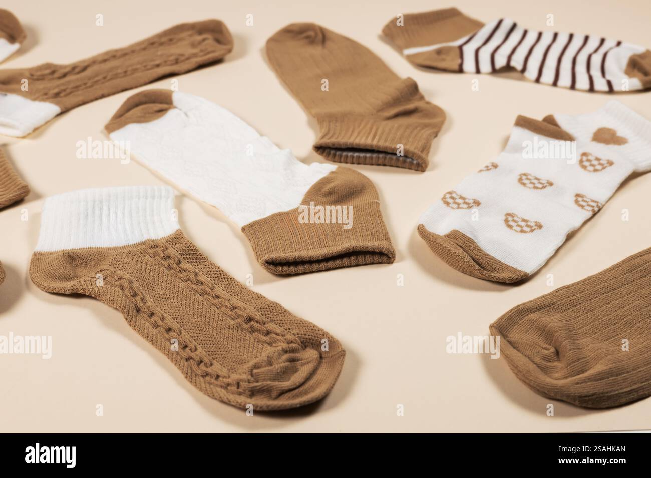 Calzini multicolore su sfondo beige. Vista dall'alto. Molte calze diverse per le stagioni fredde. I calzini sono sparsi su uno sfondo luminoso. Vestiti Foto Stock
