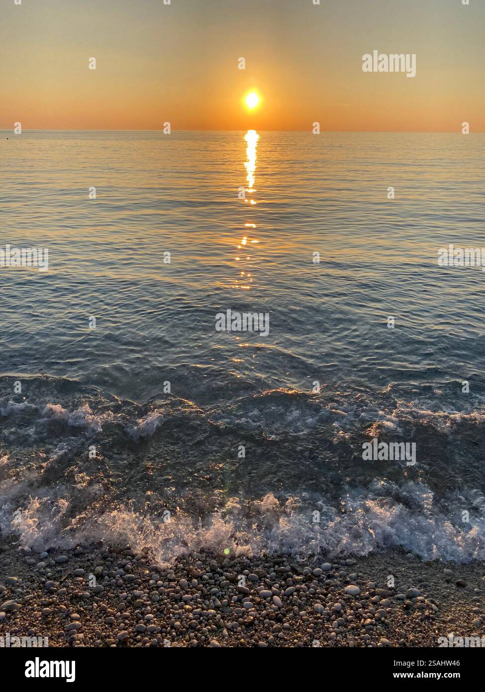 Il bellissimo sole che tramonta sulle acque calme di Ölüdeniz a Türkiye - Immagine stock catturata con smartphone