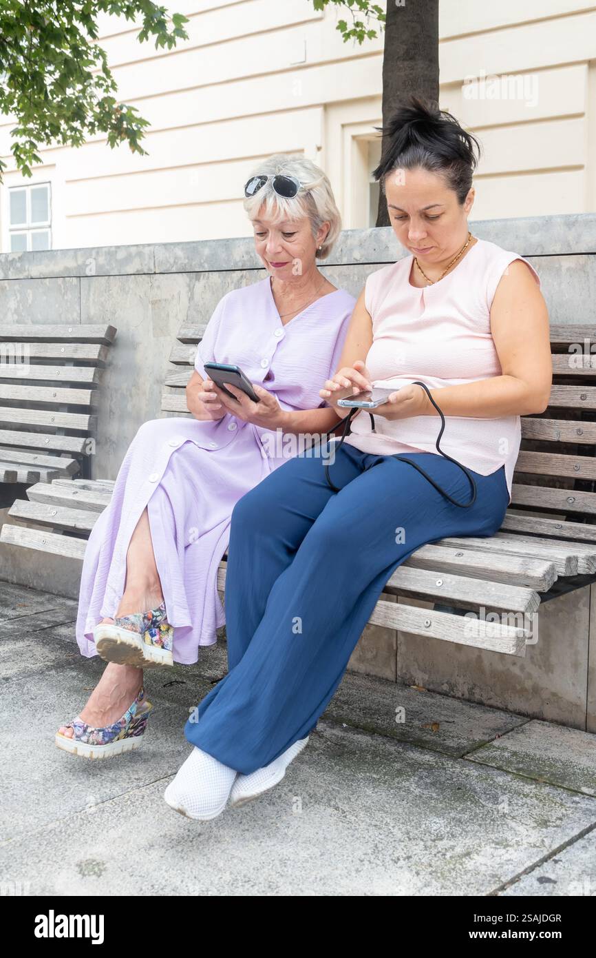La scena attuale: Le donne di tutte le età sono dipendenti dai dispositivi mobili Foto Stock