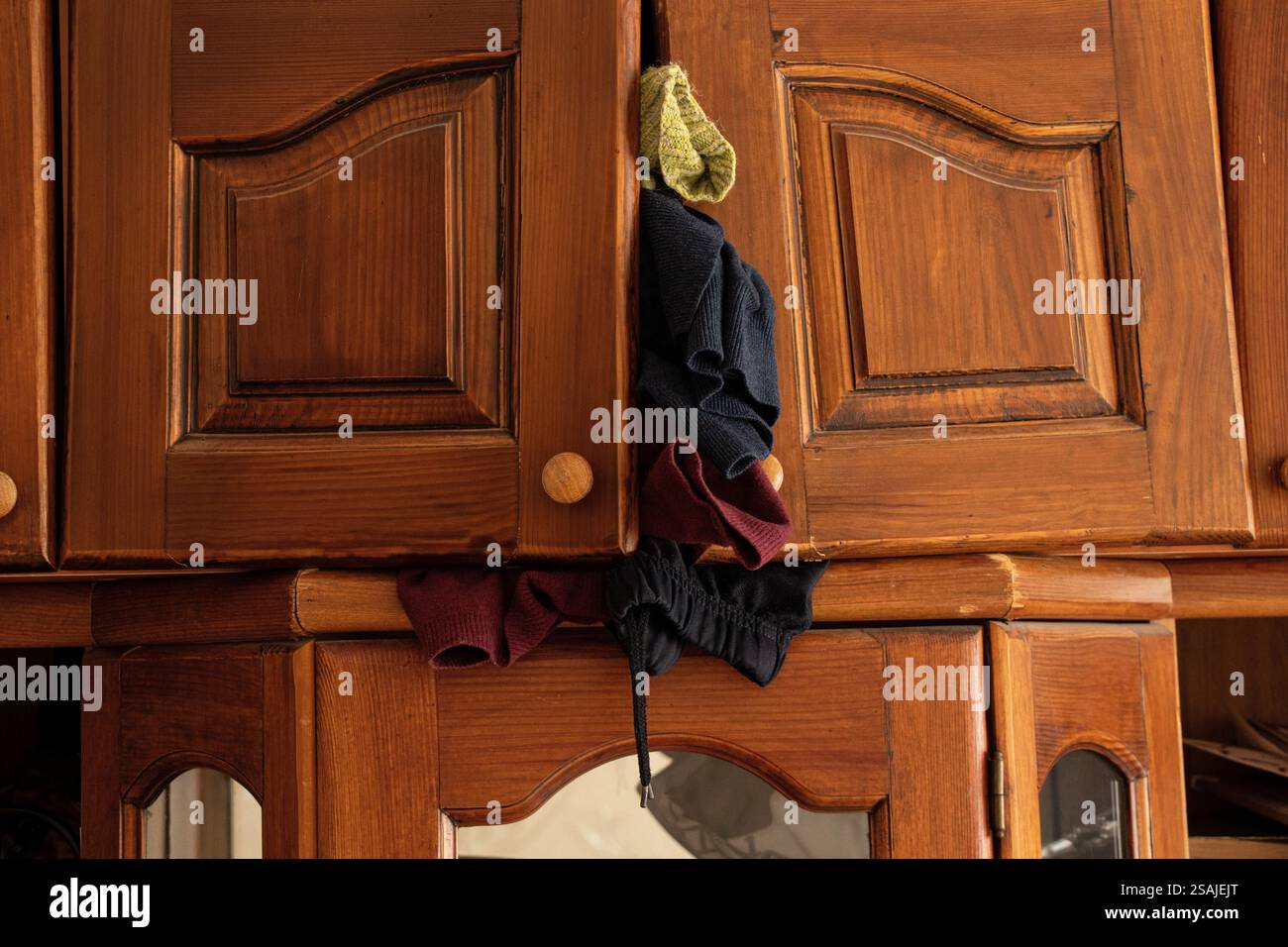 Vecchio armadio di legno da cui cadono le cose, scaffale, molte cose, pulizia della casa Foto Stock
