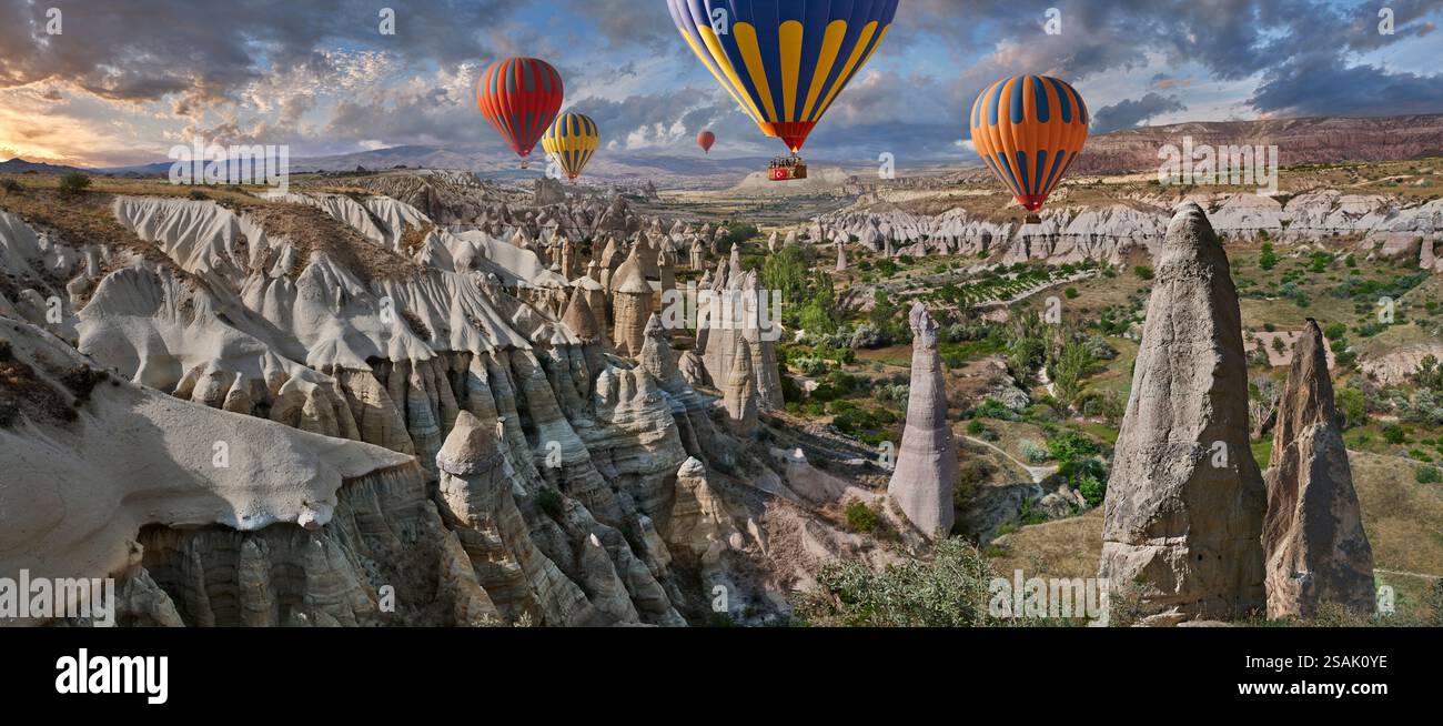 Mongolfiere che volano i turisti sulle spettacolari formazioni rocciose della "Valle dell'amore", famose in tutto il mondo, all'alba, vicino a Goreme, Cappadocia, Turchia. Foto Stock