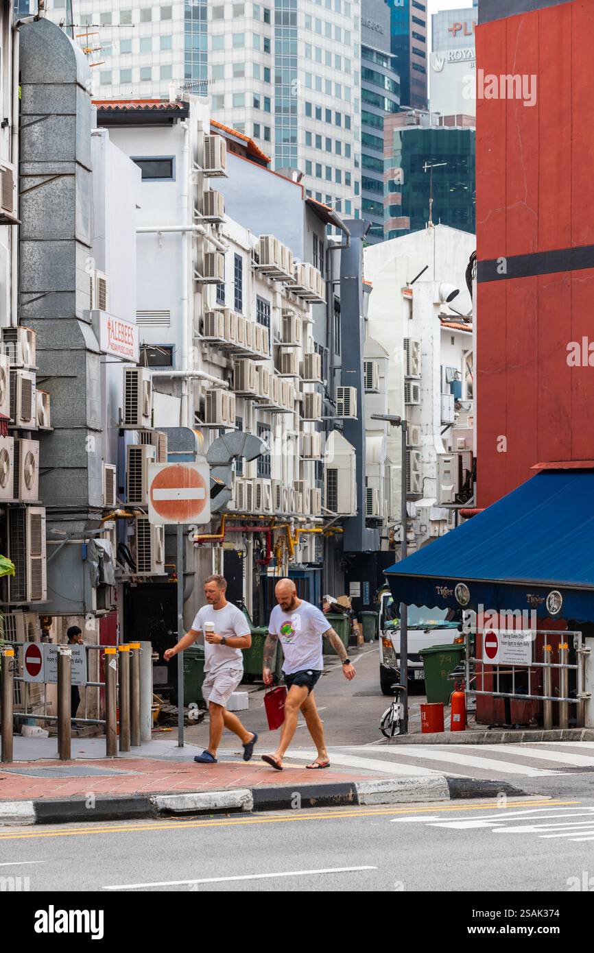 Vista tipica su una strada laterale stretta di Singapore, dove gli edifici sono pieni di condizionatori d'aria per tenere fuori il calore tropicale e l'umidità Foto Stock