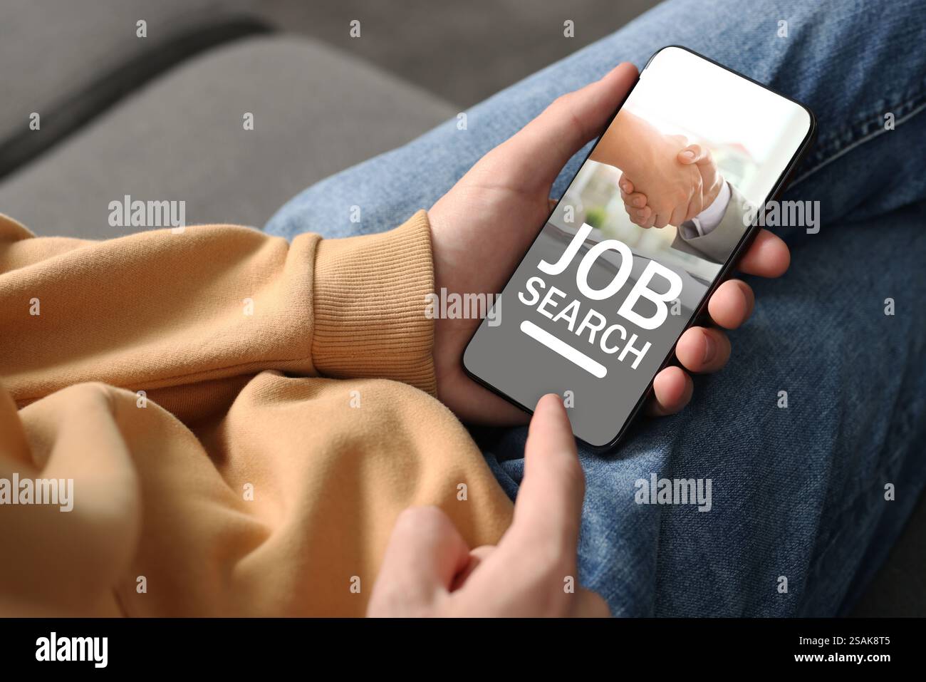 Ricerca di un lavoro. Uomo che usa il sito web per l'impiego sul cellulare a casa, primo piano Foto Stock