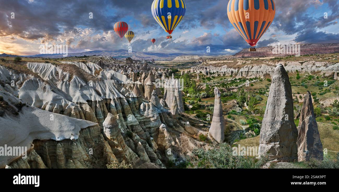 Mongolfiere che volano i turisti sulle spettacolari formazioni rocciose della "Valle dell'amore", famose in tutto il mondo, all'alba, vicino a Goreme, Cappadocia, Turchia. Foto Stock