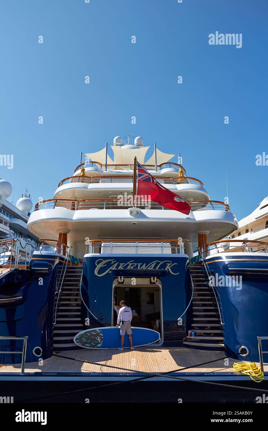 Superyacht di lusso con membro dell'equipaggio che prepara attrezzature per esterni sotto il cielo chiaro Foto Stock