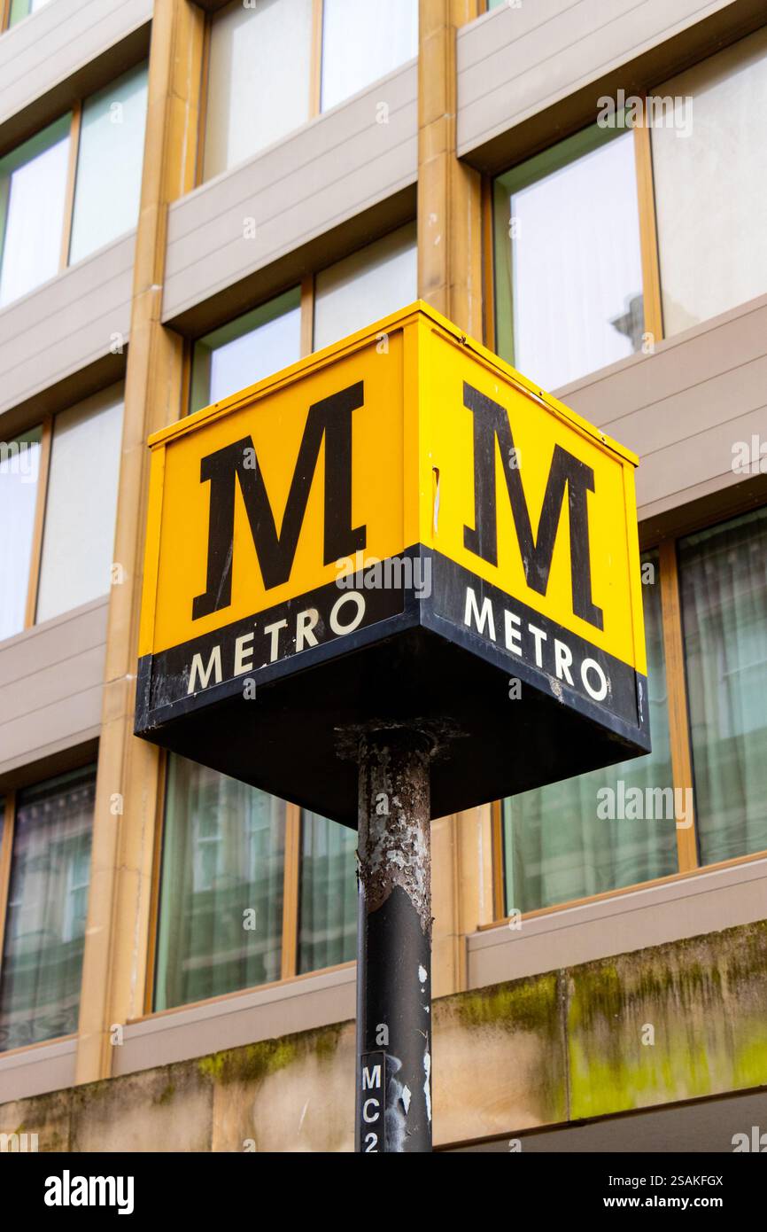 Primo piano dell'iconico cartello giallo e nero con la lettera M all'esterno di un edificio con facciata in vetro newcastle upon tyne uk Foto Stock