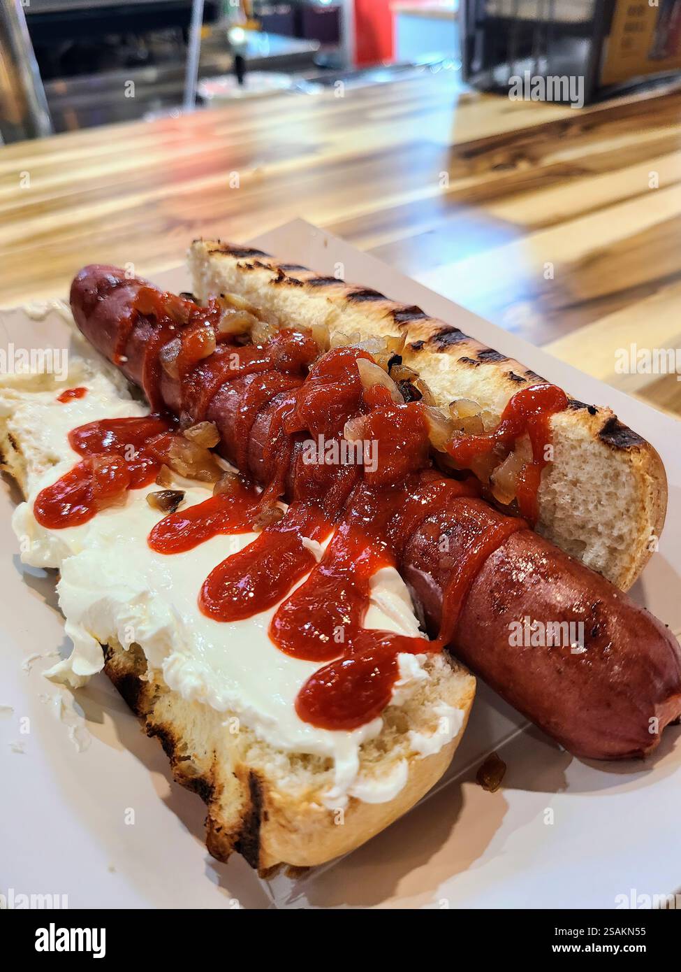 Hot Dog gourmet di Seattle con condimenti su un banco in legno con vista a livello dell'occhio Foto Stock