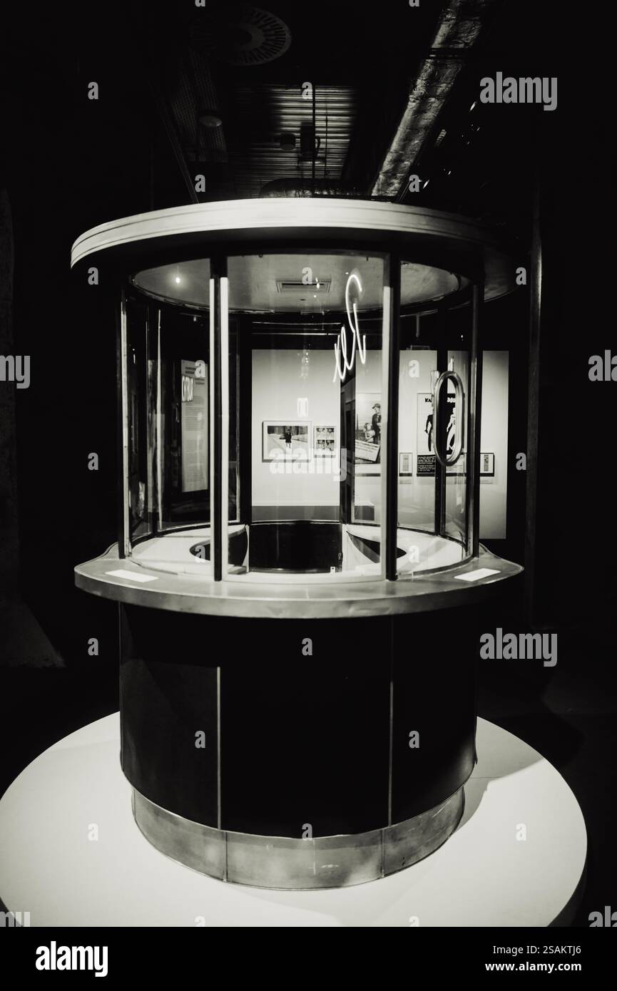 Immagine in bianco e nero di una biglietteria cinematografica d'epoca con una struttura rotonda in vetro. Una rappresentazione nostalgica di cinema classici e retrò Foto Stock