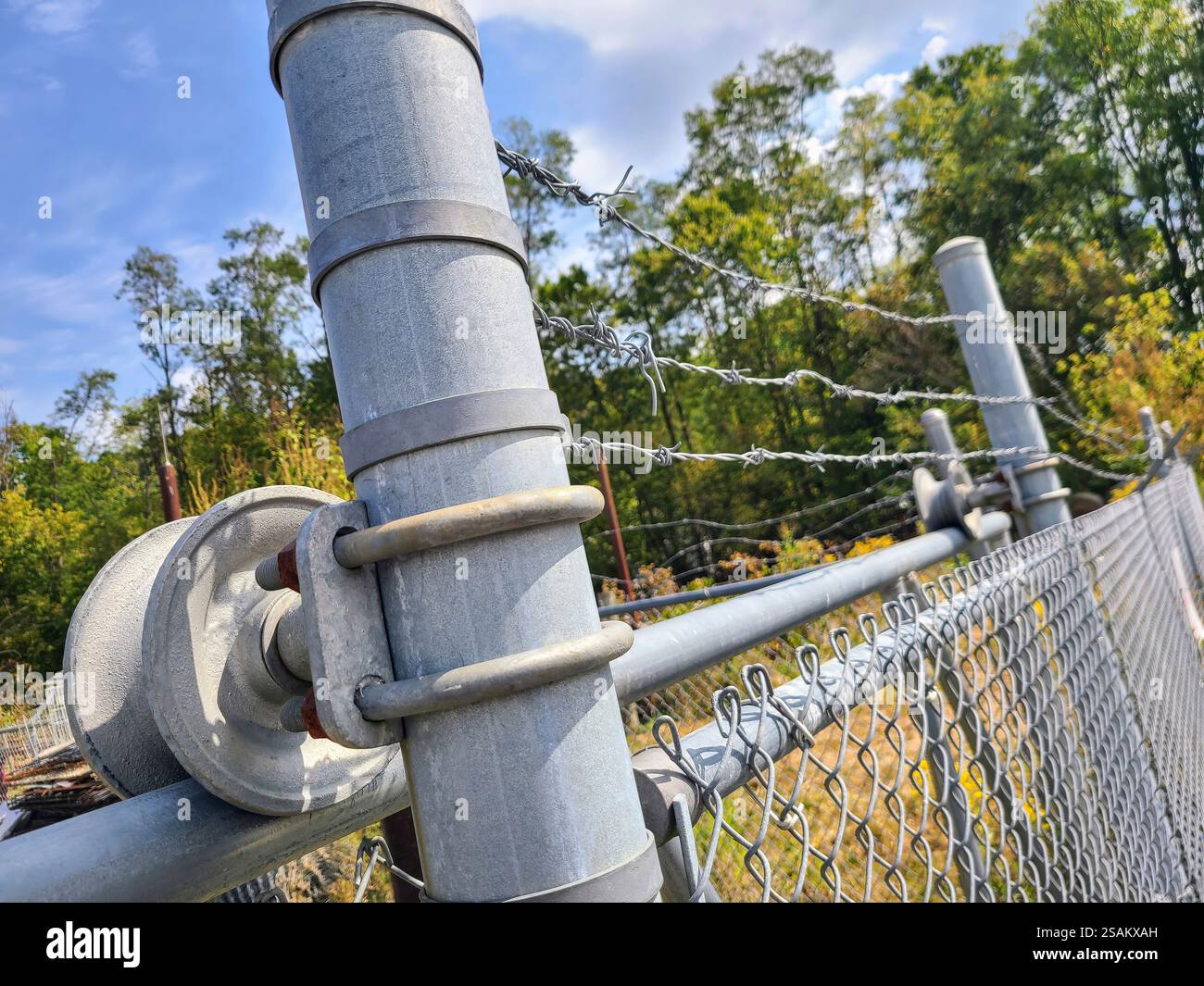 Recinzione di sicurezza con filo spinato e prospettiva di primo piano verde Foto Stock